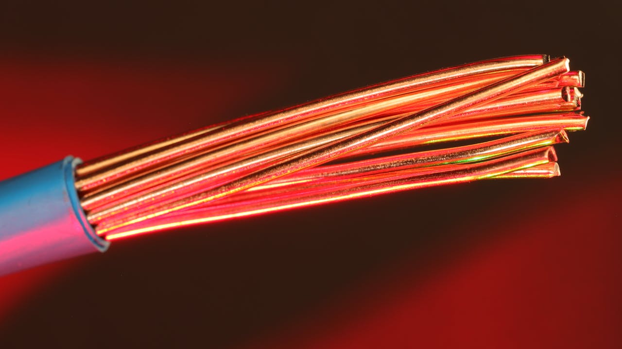 our-services-2 Detailed image of copper wires illuminated by red light, highlighting texture and color.