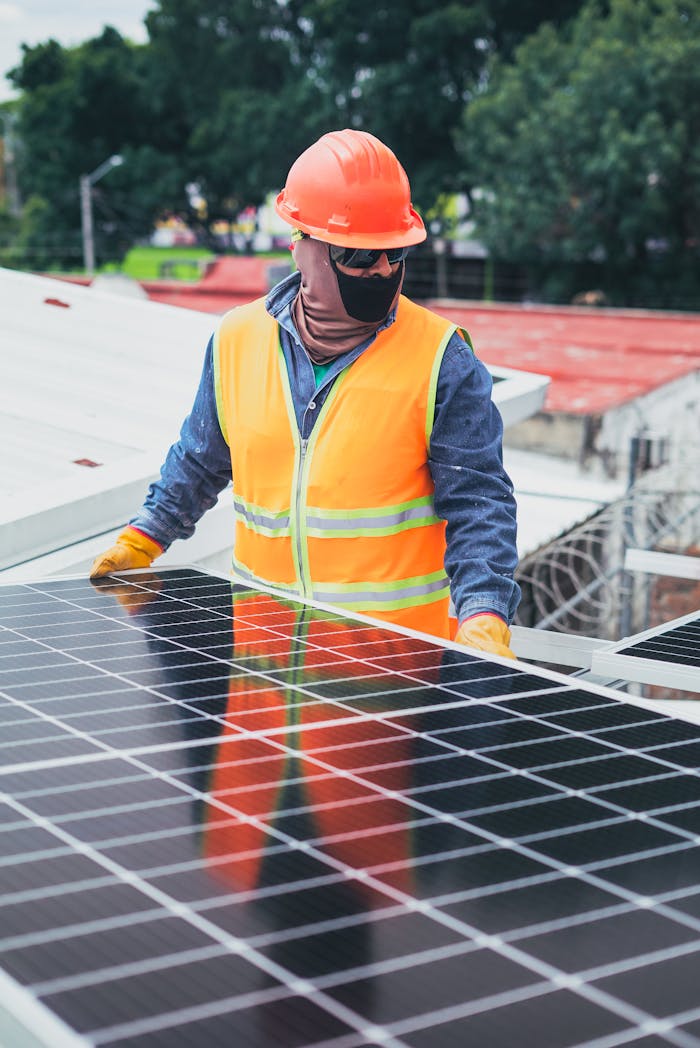 gallery-6 Technician in protective gear installing solar panels on a sunny day.