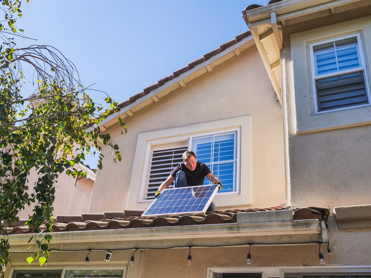 about-img Solar technician installing photovoltaic panels on a sunny rooftop.